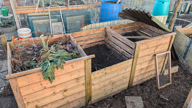 Drie 1 kuub compostbakken gemaakt van pallethout voor tuincompostering